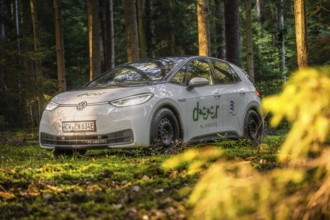 Car in the forest in natural sunlight, peaceful and green environment, VW ID3 electric car, Deer