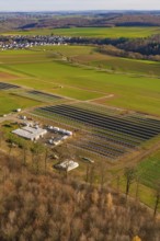 Solar system and building nestled in a green landscape with village surroundings in autumn, energy