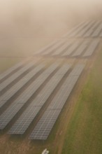 Landscape with solar panels in fog, atmospherically dense and sustainable, energy transition,