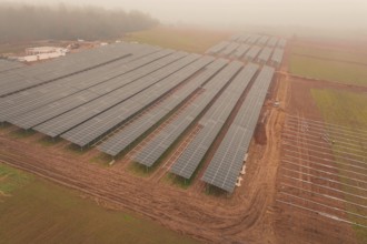 Solar fields under fog, sustainable energy in a wide field landscape, energy revolution,