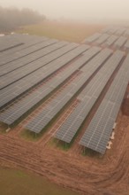 Foggy fields with solar panels, highlights rural and sustainable energy production, energy