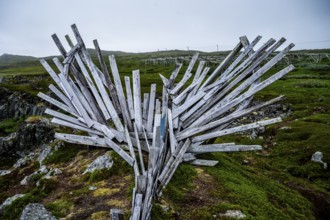 Wooden sculpture with dynamic shapes in a natural environment, Drakkar Vardø sculpture. The