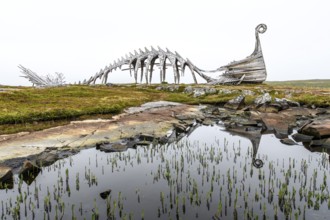 Wooden sculpture of a Viking ship and its reflection in a body of water, sculpture by Drakkar Vardø