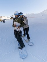 Couple wearing warm winter apparel and protective headgear smiling and posing for a selfie while