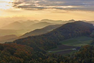 View of an autumnal forest from the Gisliflue, behind the Jurassic foothills with the water fluh in