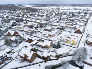 Snowy residential area with close-standing houses and snow-covered roads, aerial view, Oelsburg,