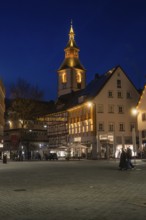 Church tower and half-timbered houses stylishly illuminated at night on a town square, Nagold, Calw