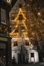 An old building is illuminated in warm lights for Christmas and gives the old town a festive light