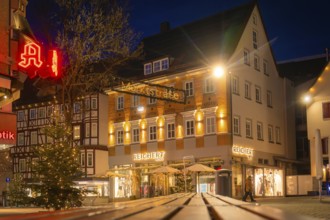 Historic street with illuminated shops and Christmas decorations in the evening mood, Nagold, Calw