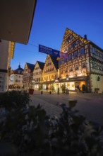 Illuminated houses with traditional architecture and ice banners at night, Nagold, Calw district,