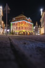 Night view of a historic building illuminated with a colorful light projection, Nagold, Calw