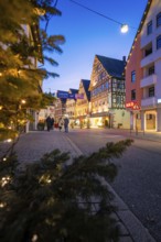 City street with illuminated half-timbered houses and festive lighting, walkers, Nagold, Calw