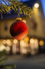 Red Christmas ball on pine branch, blurred background with lights, Nagold, Calw district, Black