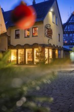 Commercial building with Christmas decoration and half-timbering at dusk, Nagold, Calw district,