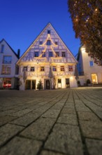 Half-timbered house with Christmas tree-shaped fairy lights against evening sky, Nagold, Calw