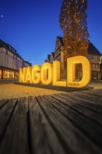 Illuminated Nagold lettering at dusk, surrounded by medieval buildings, Nagold, Calw district,