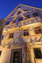 Fairy lights in tree silhouette on the façade of a furnished house, Nagold, Calw district, Black