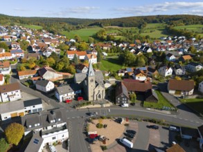 Aerial view of a village church on a square surrounded by autumn trees, aerial view, Niederkalbach,
