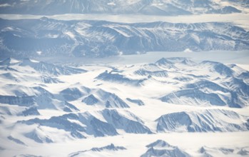 Icy, snowy arctic mountain landscape with glaciers and fjords, aerial view, Greenland, Arctic