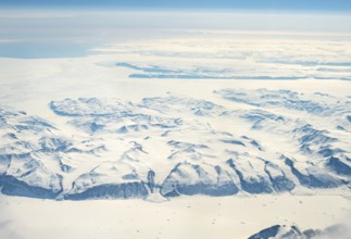 Wide snowy landscape with mountain ranges and huge glaciers, aerial view, Greenland, Arctic