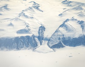 Glacier tongue flows into huge glaciers, snowy arctic mountain landscape, aerial view, Greenland,