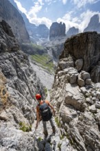 Mountaineers on a via ferrata in front of a picturesque mountain landscape with rocky peaks, Via