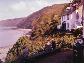 View of coastline with wooden cliffs from the harbour at Clovelly, north Devon, England, UK 1960s