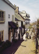 Steep hill of cobbled main street in coastal village of Clovelly, north Devon, England, UK 1960s