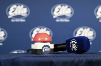 The microphone and a buzzer are on the table in front of the red button is pressed at 12:00 and