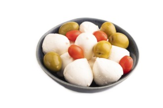 White Mozzarella cheese, with tomatoes and olives in blue bowl Isolated on white background, side