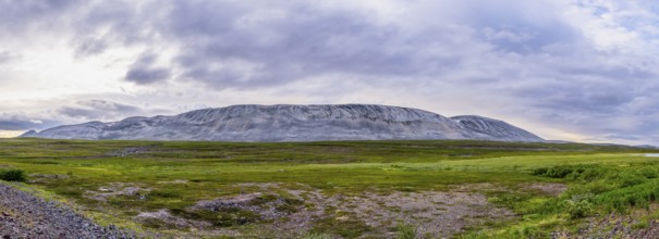 A massive granite rock mountain with bare fells dominates the landscape of the central Varanger