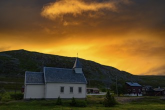 Nordford chapel on Ytre Syltefjord under a dramatic evening sky surrounded by cloudy sky, small