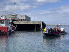 Port of the town of Vardö with the harbour master's ship and the incoming inflatable boat Speedboat