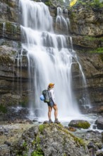Young woman in front of Cascata di Mezzo waterfall, long exposure, Vallesinella, Brenta, Trentino,