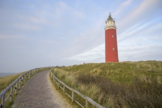 Red lighthouse of de Cocksdorp in the north of the island of Texel rises against the sky on grassy