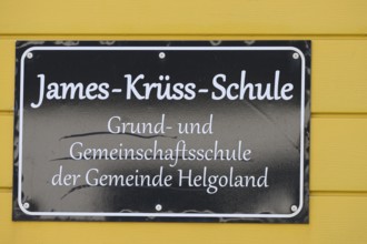 James Krüss School sign on yellow background in Heligoland, Heligoland, Schleswig-Holstein, Germany