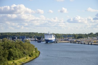 Scandinavienkai Tavemünde with large Finnlines ferry in port, surrounded by water and fluffy