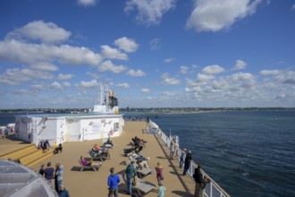 People relax on a TT-Line ship deck with a view of the sea under a blue sky, Trelleborg, Skåne län,