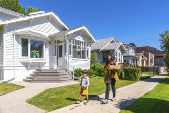Mother and son are walking back home after picking up a food delivery order on a sunny summer day