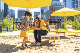 Mother and her son are spending quality time together at an urban beach in calgary, sheltered by
