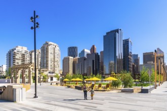 Modern skyscrapers rise above a newly developed urban park in calgary's east village, where a