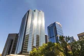 Sun reflecting on glass skyscrapers in downtown calgary, canada, creating a vibrant and dynamic