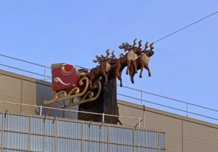 Carriage with reindeer sleigh stands ready for Santa Claus in the sky of the savings bank building,