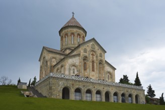 Stone church against a cloudy sky on a hill with strong architectural details, Bodbe monastery,