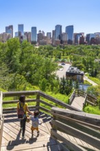 Mother and son descending a wooden staircase in a park, enjoying a picturesque view of the calgary