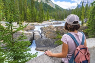 Female tourist with backpack enjoying the breathtaking view of the bow river natural bridge, a