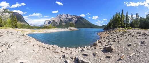 Turquoise waters of lake minnewanka reflecting surrounding mountains and forests in banff national
