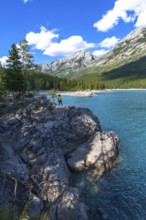 Tourist enjoying the stunning turquoise waters of lake minnewanka, surrounded by the majestic