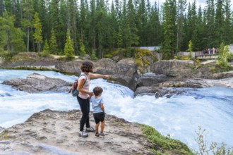 Mother and son enjoying the stunning view of bow river's natural bridge in banff national park,
