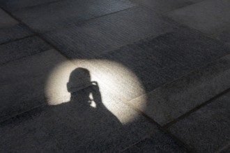 Head of a photographer in light on a stone floor, Abu Dhabi, United Arab Emirates